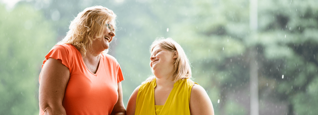 A care giver and female smiling at each other.