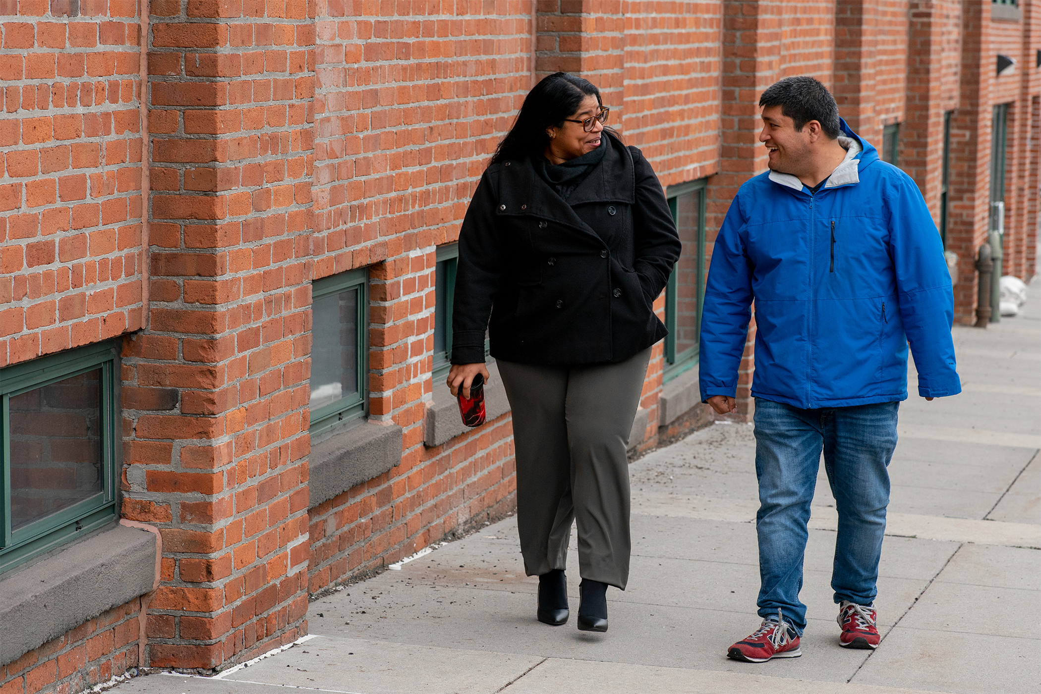 A woman and a man are walking and talking.