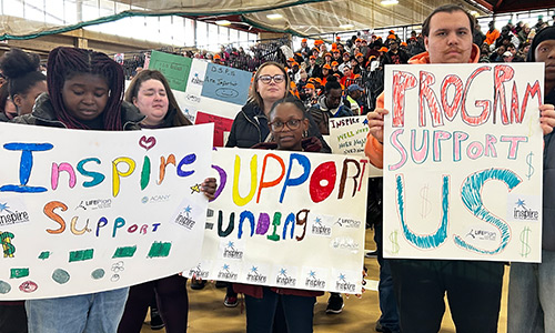 a group of self-advocates at a rally holding signs