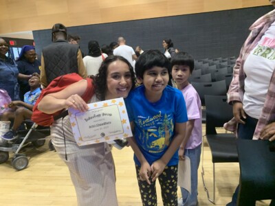 ACA/NY member Aritri Chowdhury posing with adult after receiving Technology Genius Certificate from their school.